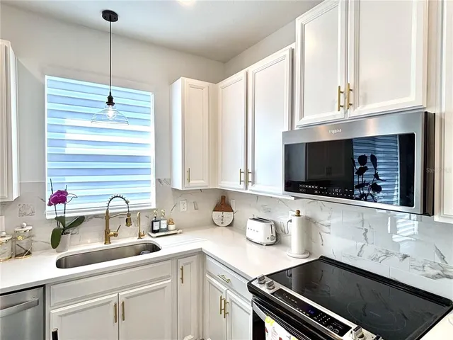 a kitchen with a sink stove and cabinets