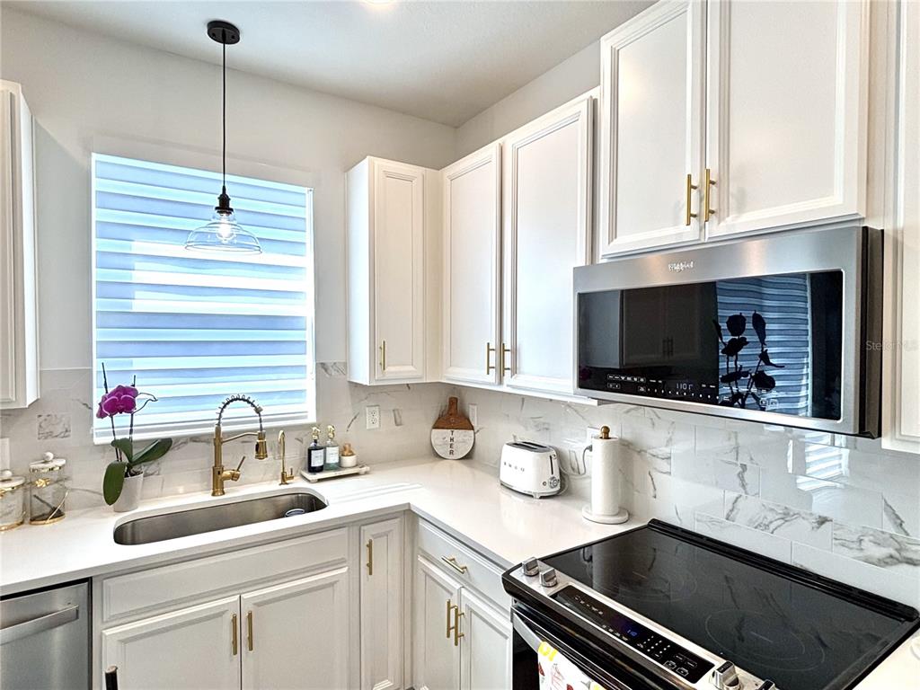 921 Spring Palms Loop Orlando, FL 32828 - Photo 18 of 43 a kitchen with a sink stove and cabinets