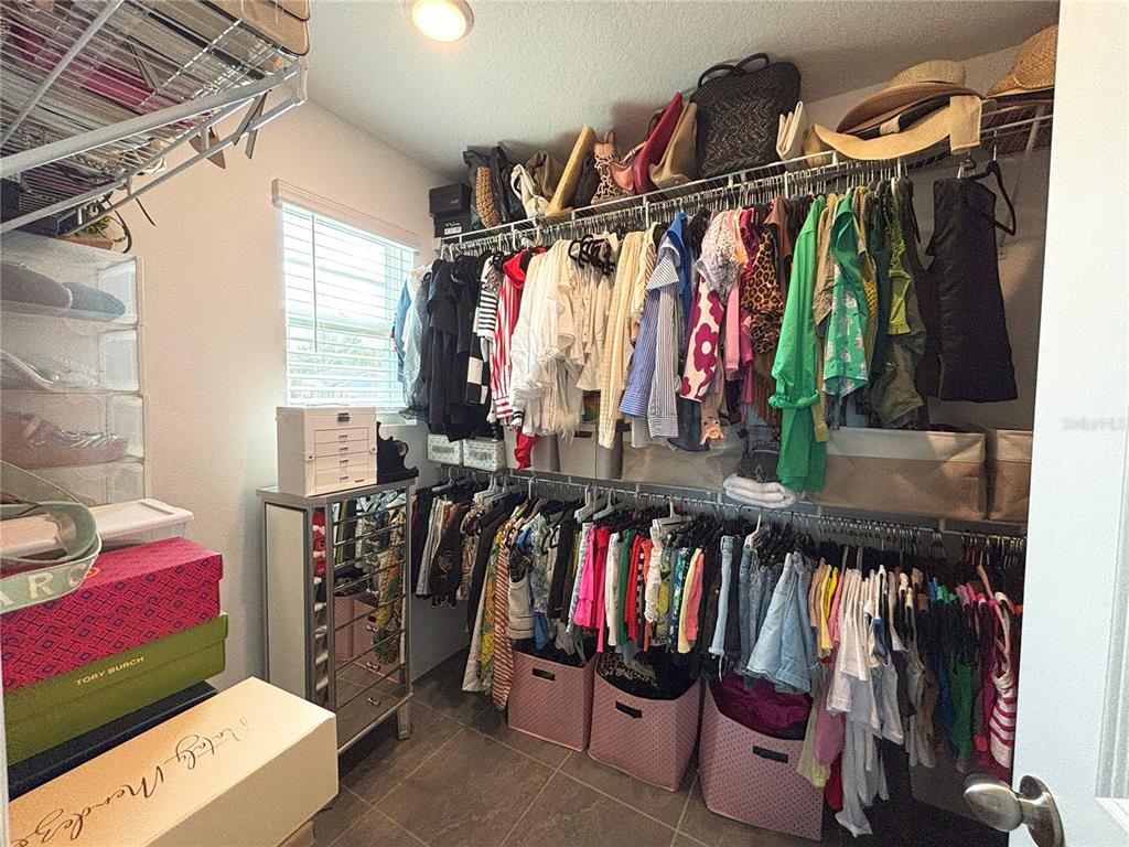 921 Spring Palms Loop Orlando, FL 32828 - Photo 26 of 43 a view of walk in closet with clothes and shoes