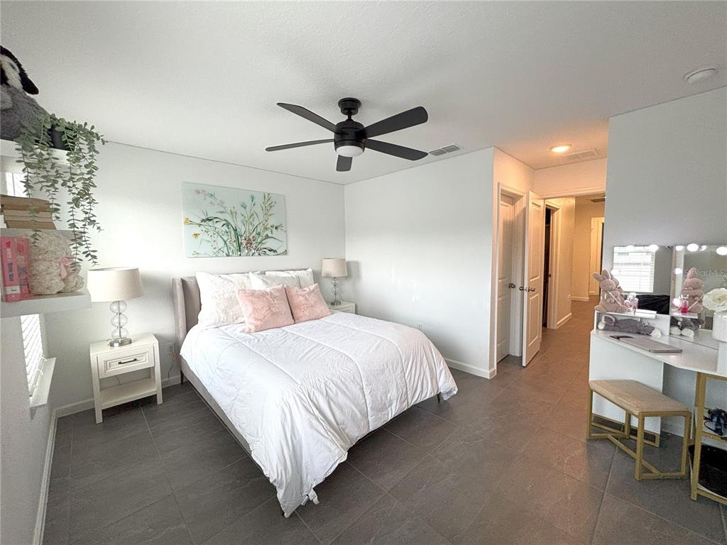 921 Spring Palms Loop Orlando, FL 32828 - Photo 27 of 43 a bedroom with bed and a chandelier