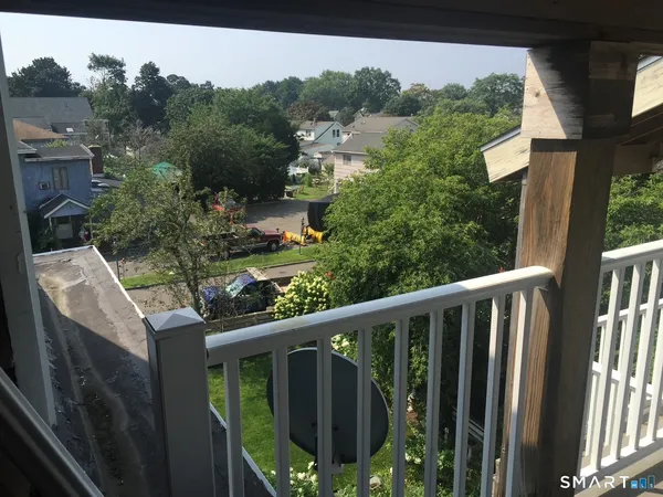 a view of a balcony with wooden floor and outdoor seating