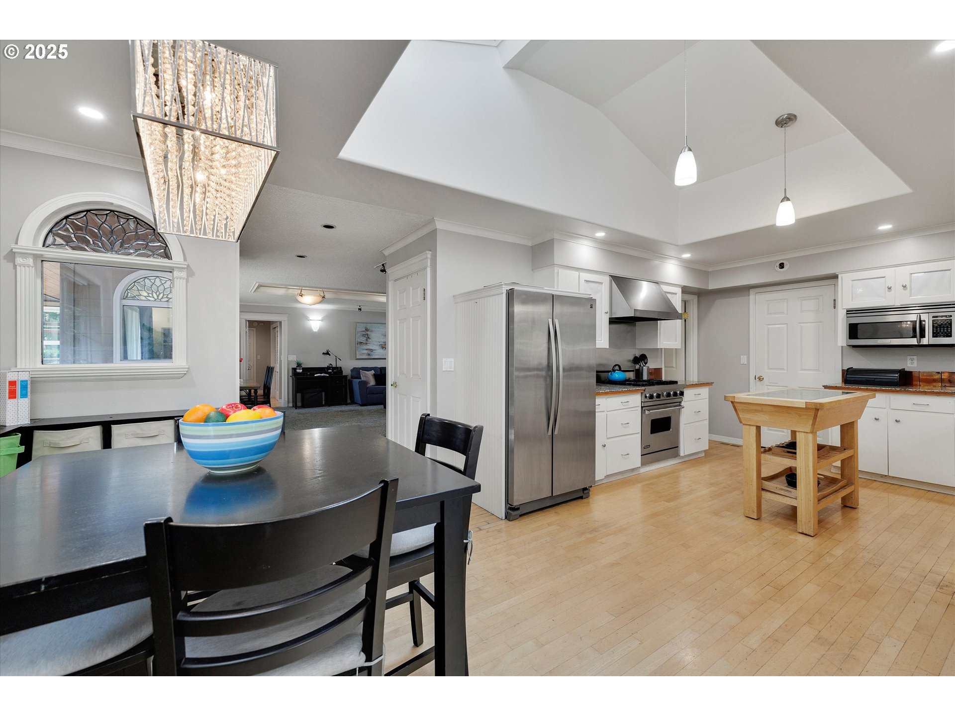 8815 Southwest Oleson Road Portland, OR 97223 - Photo 20 of 46 a kitchen with stainless steel appliances kitchen island granite countertop a table chairs stove and refrigerator