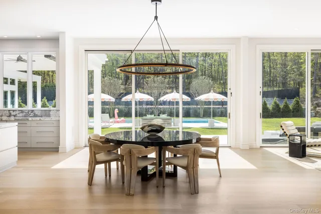 a dining room with wooden floor glass table and chairs
