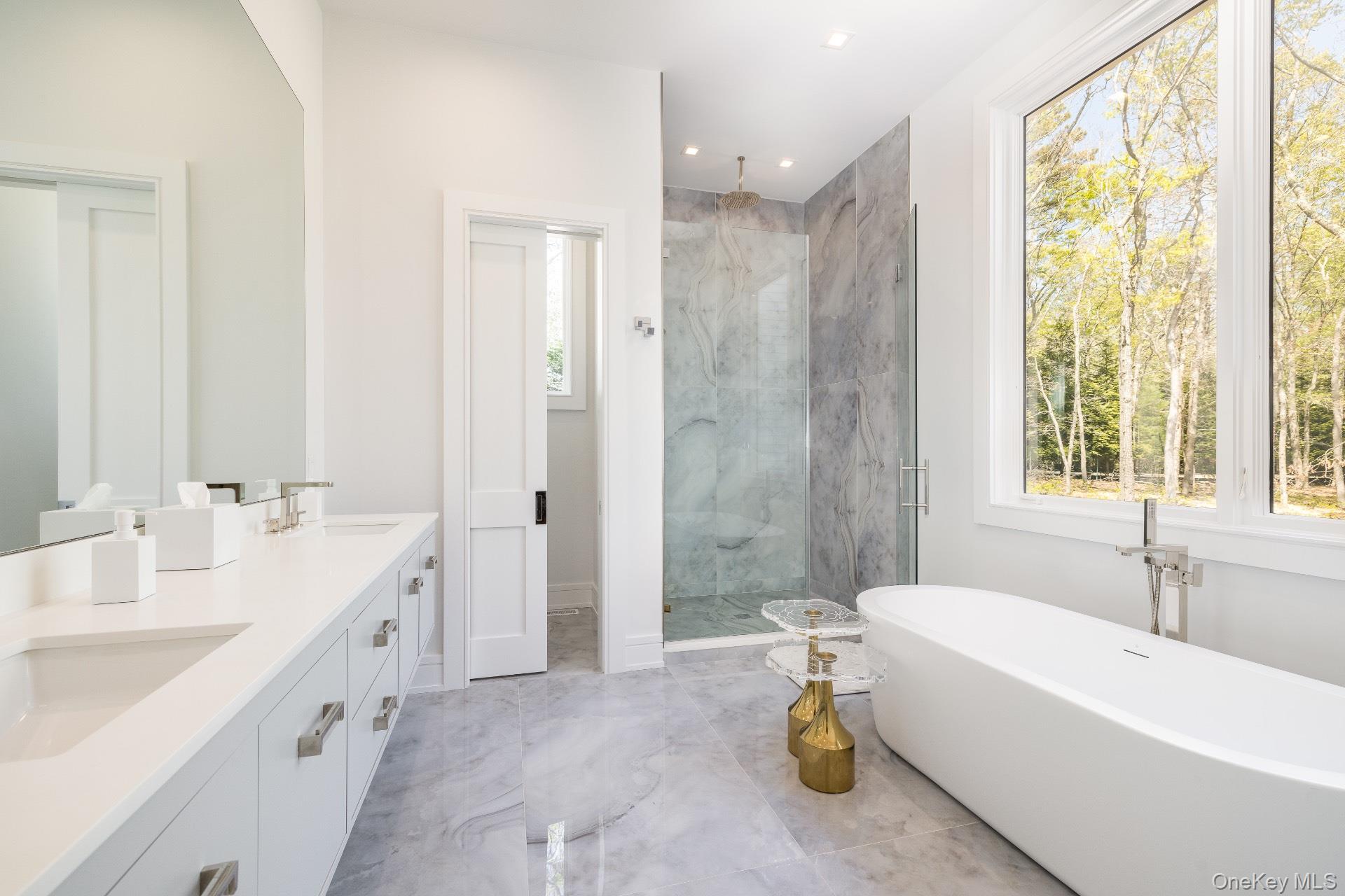 1552 Deerfield Road Water Mill, NY 11976 - Photo 25 of 37 a spacious bathroom with a tub sink shower and a mirror