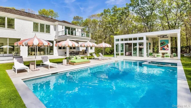 swimming pool view with a seating space and a garden view