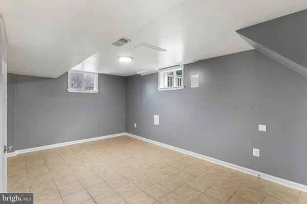 an empty room with windows and chandelier fan