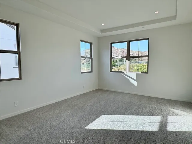 an empty room with windows and cabinet
