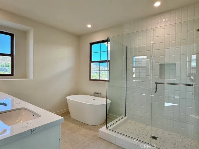 a bathroom with a granite countertop sink a toilet a mirror and bathtub