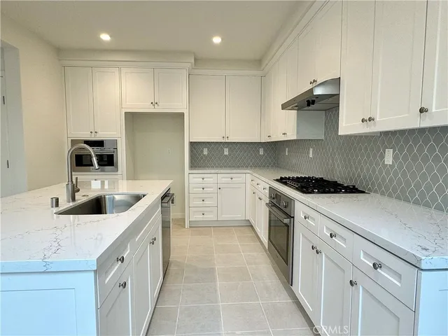 a kitchen with a stove a sink a refrigerator and cabinets
