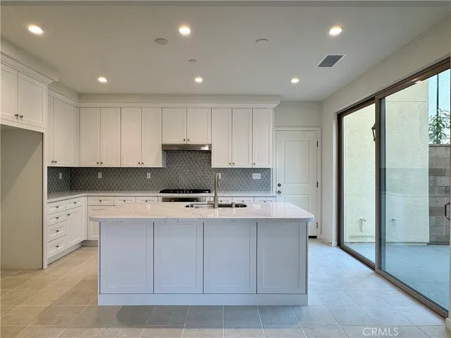 a large white kitchen has a large window