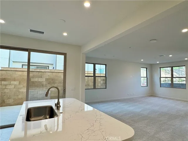 a view of an empty room with a window and fireplace