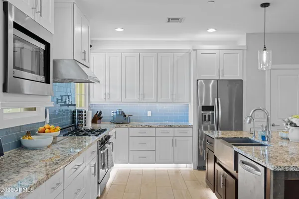 a kitchen with stainless steel appliances granite countertop a sink stove and refrigerator