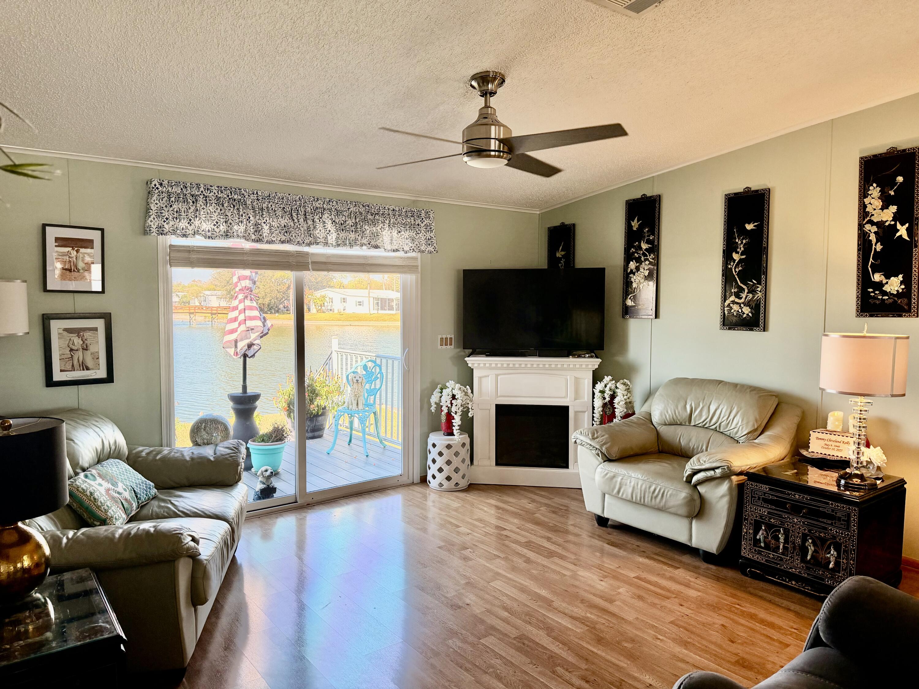 1692 Southwest 35th Circle Okeechobee, FL 34974 - Photo 4 of 30 a living room with furniture a fireplace and a flat screen tv