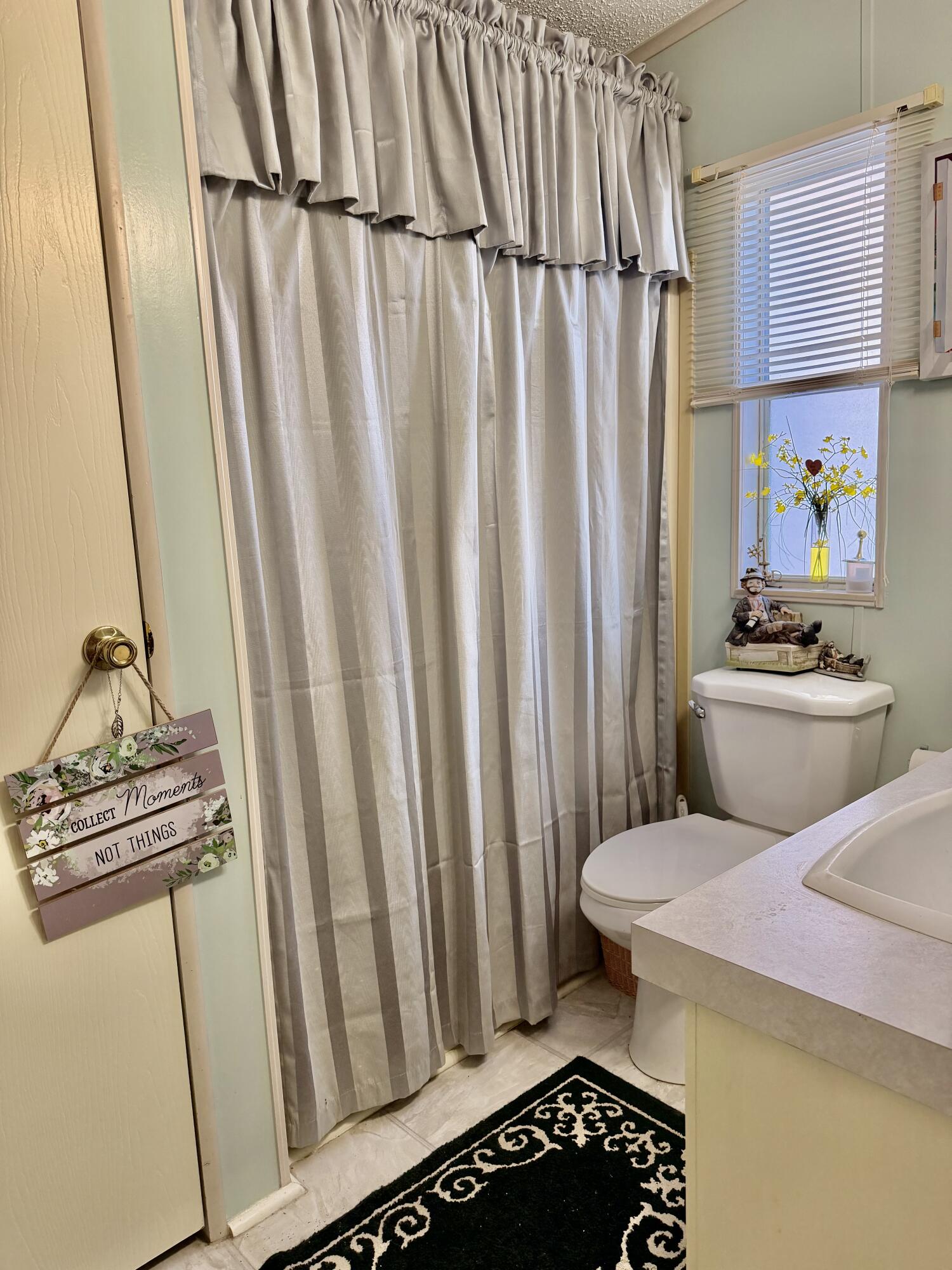 1692 Southwest 35th Circle Okeechobee, FL 34974 - Photo 10 of 30 a bathroom with a sink a toilet a window and shower
