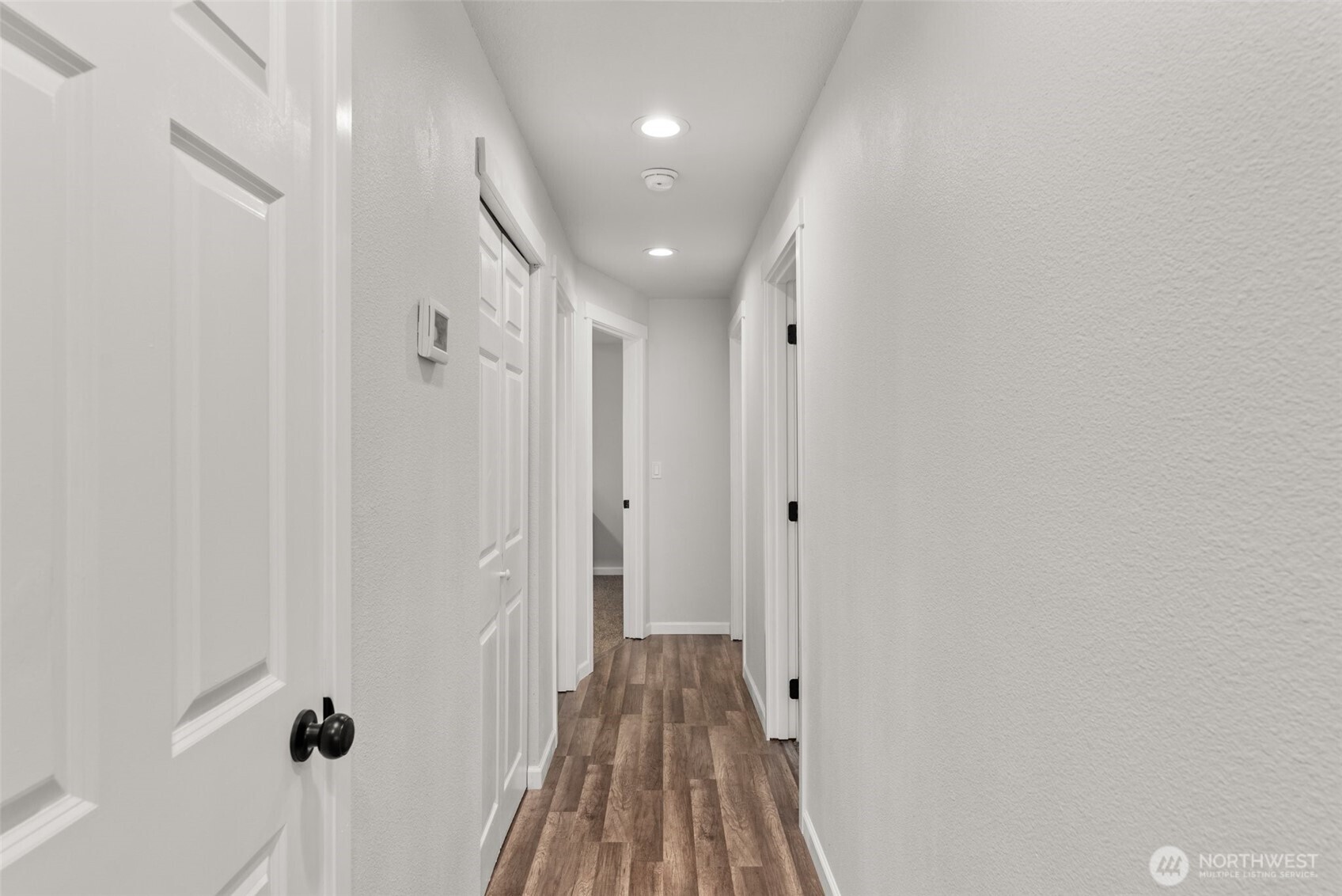 9037 178th Avenue Southwest Rochester, WA 98579 - Photo 12 of 33 a view of a hallway with wooden floor and a bathroom