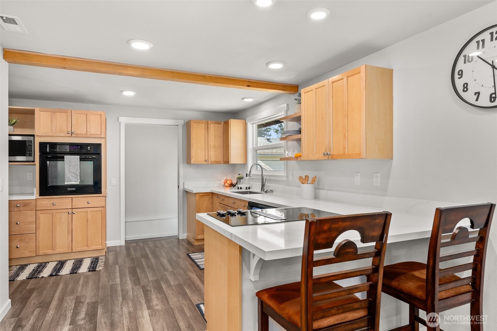 9037 178th Avenue Southwest Rochester, WA 98579 - Photo 8 of 33 a kitchen with stainless steel appliances granite countertop a stove top oven a sink a dining table and chairs with wooden floor