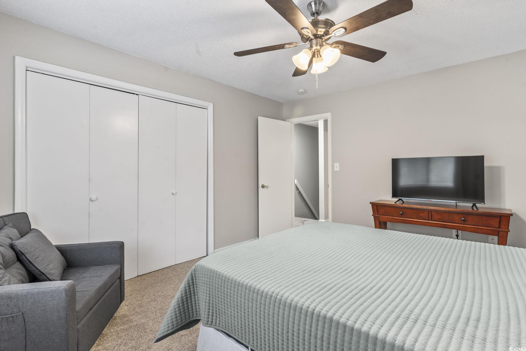 86 Beaver Pond Loop, Unit 33 Pawleys Island, SC 29585 - Photo 15 of 25 Bedroom featuring carpet flooring, a closet, ceiling fan, and a textured ceiling