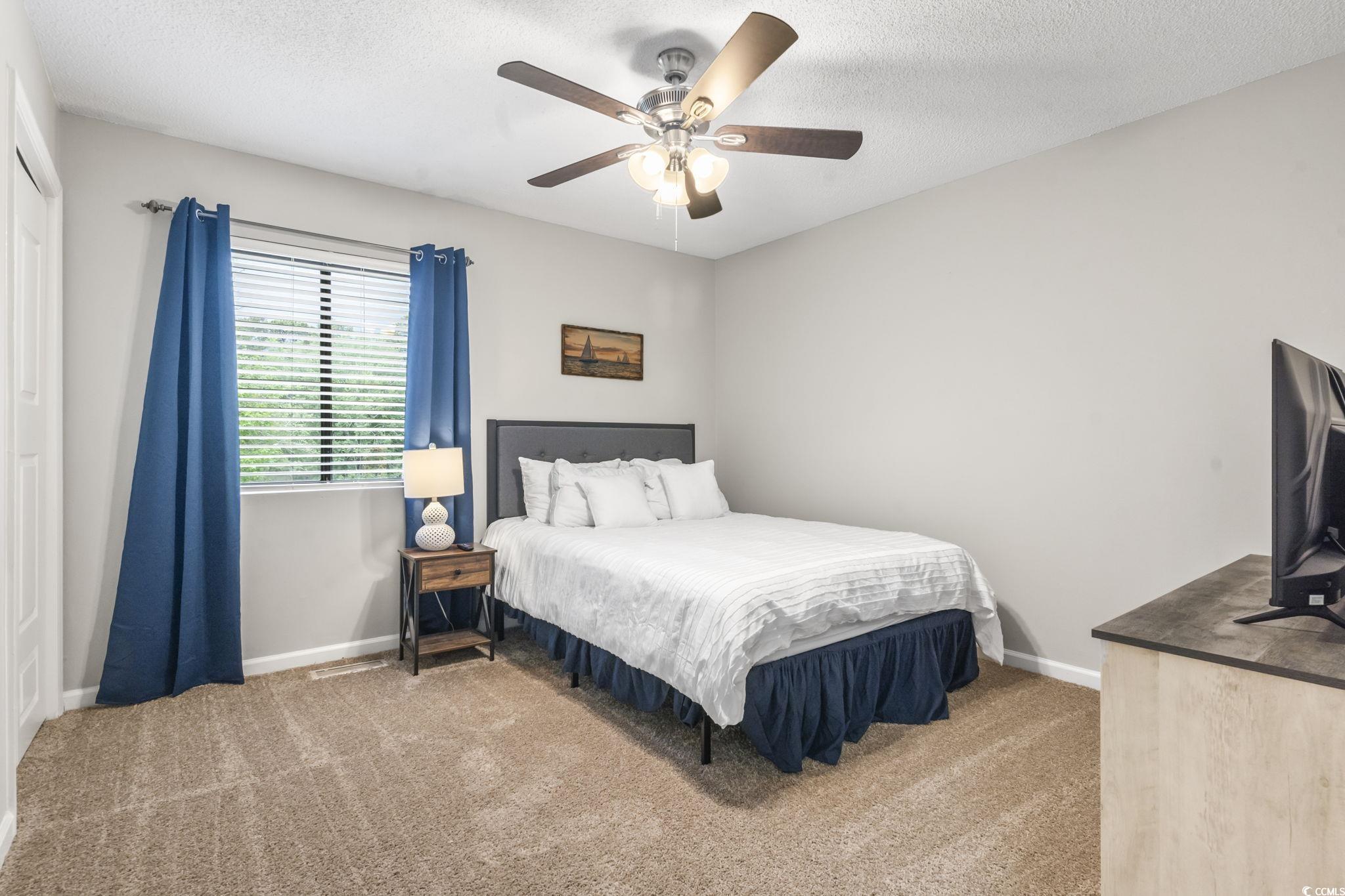 86 Beaver Pond Loop, Unit 33 Pawleys Island, SC 29585 - Photo 18 of 25 Bedroom with light colored carpet, a textured ceiling, and a ceiling fan