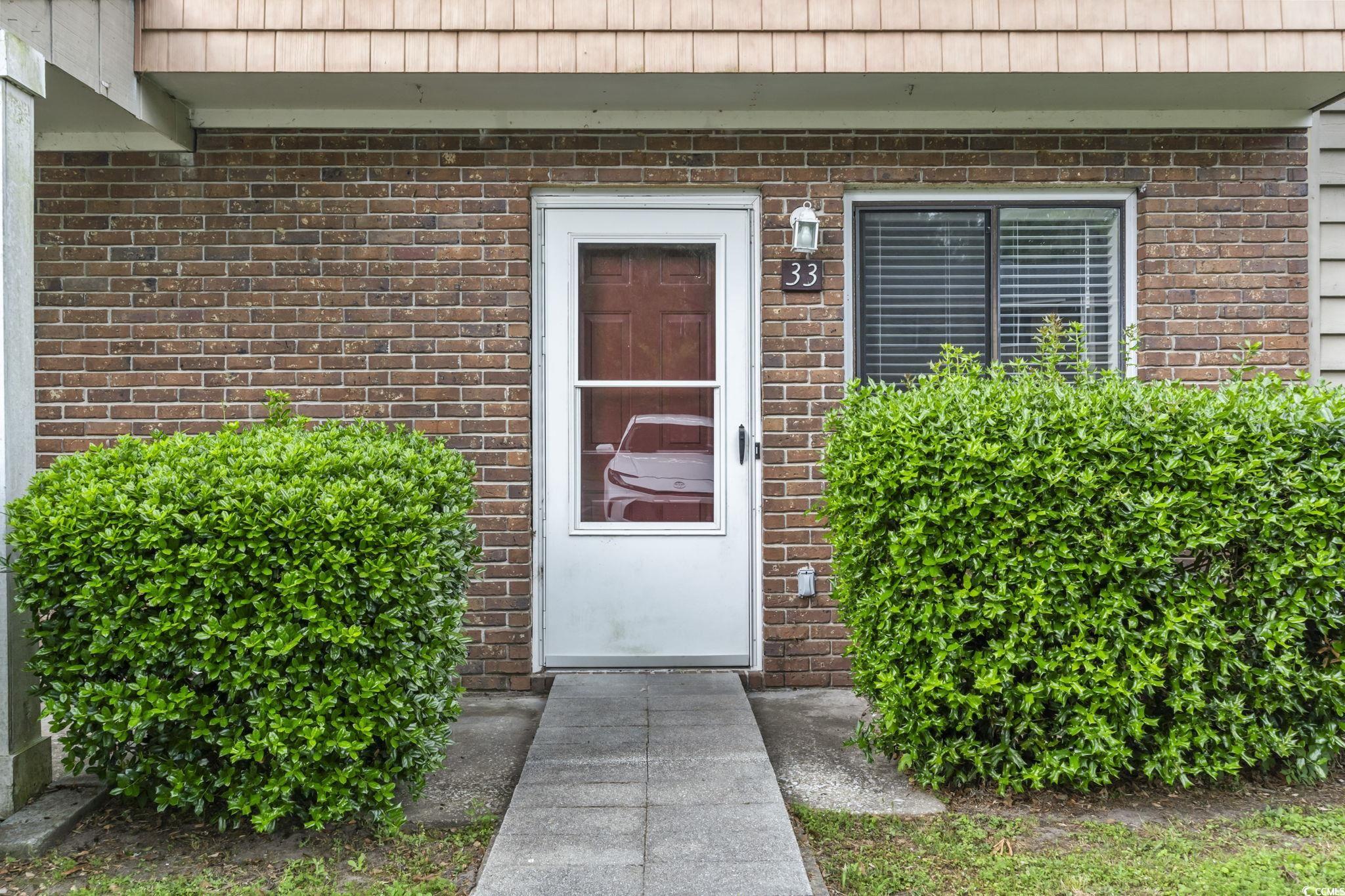 86 Beaver Pond Loop, Unit 33 Pawleys Island, SC 29585 - Photo 21 of 25 Entrance to property with brick siding