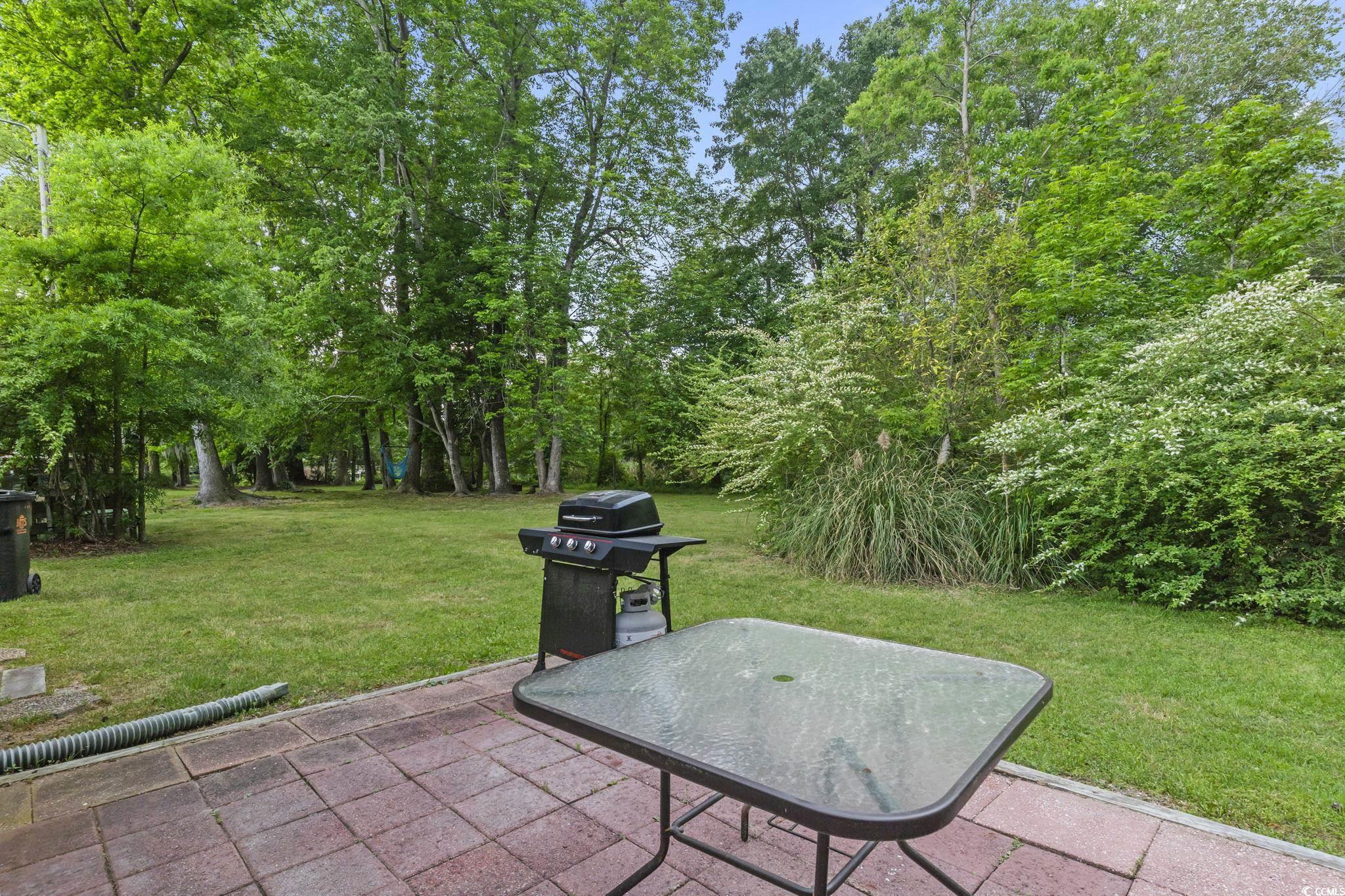 86 Beaver Pond Loop, Unit 33 Pawleys Island, SC 29585 - Photo 23 of 25 View of patio / terrace with a grill and view of wooded area