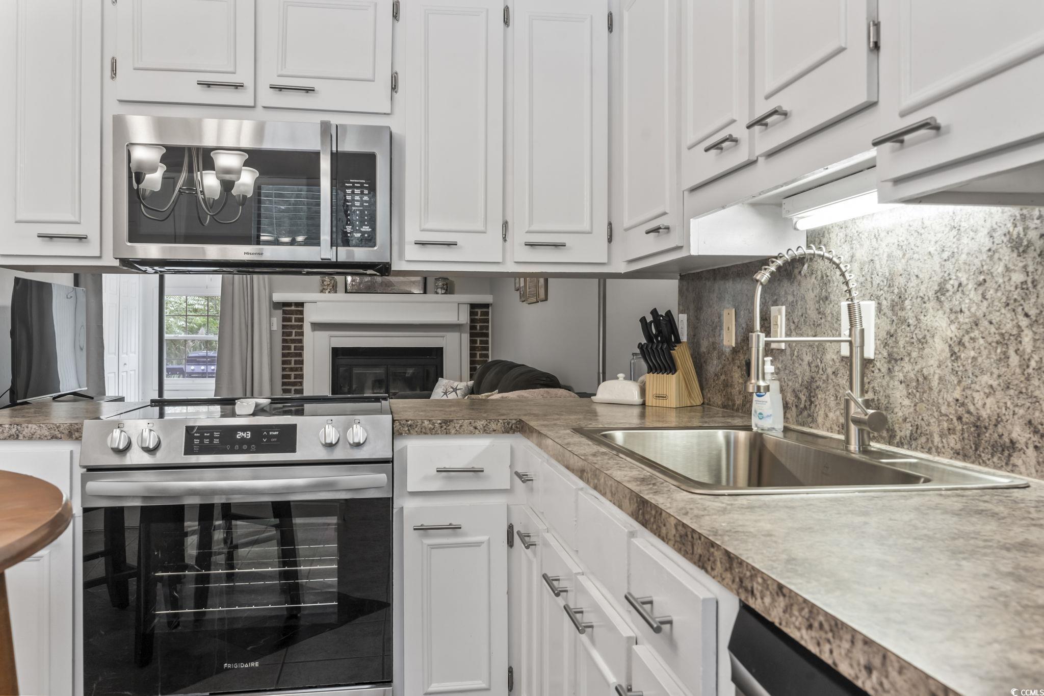 86 Beaver Pond Loop, Unit 33 Pawleys Island, SC 29585 - Photo 25 of 25 Kitchen featuring white cabinets, appliances with stainless steel finishes, decorative backsplash, a chandelier, and open floor plan
