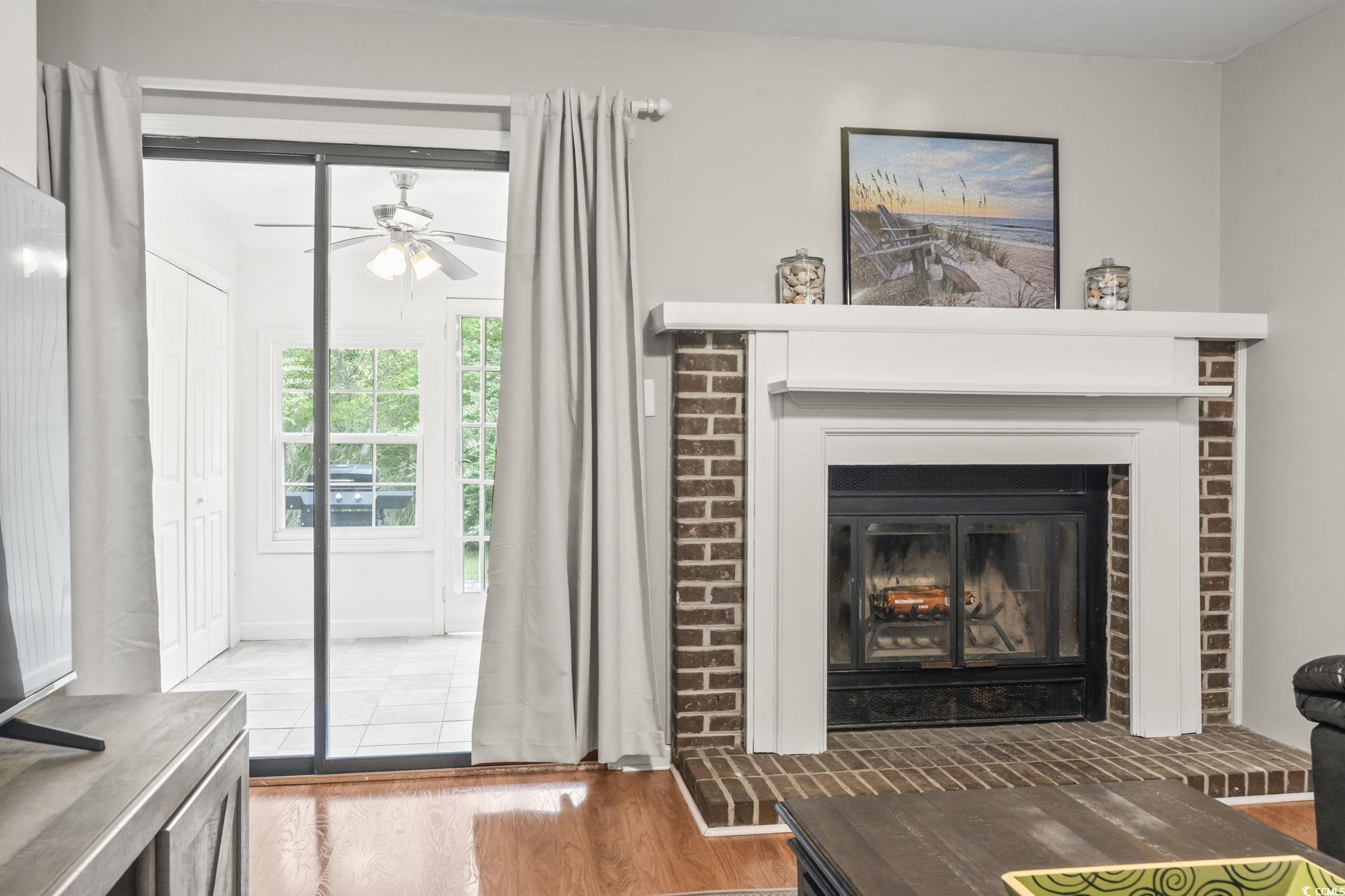 86 Beaver Pond Loop, Unit 33 Pawleys Island, SC 29585 - Photo 9 of 25 Detailed view of wood finished floors, a fireplace, and a ceiling fan
