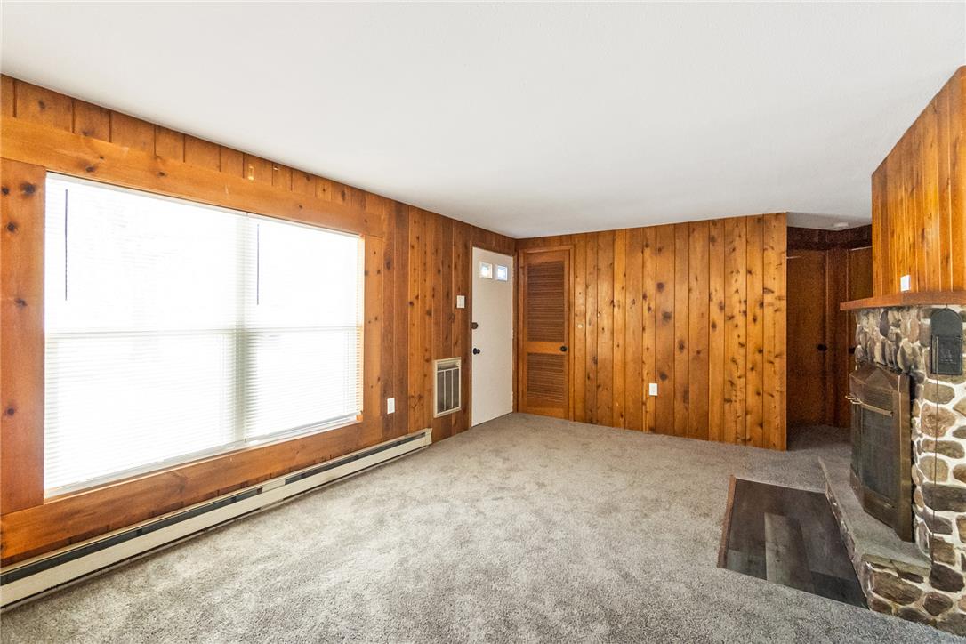 121 Short Ridge Road Albrightsville, PA 18210 - Photo 33 of 35 Rich wood paneling and a stone fireplace create a warm, rustic cabin ambiance.