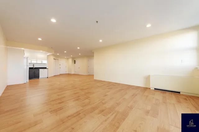 a view of empty room with wooden floor and window