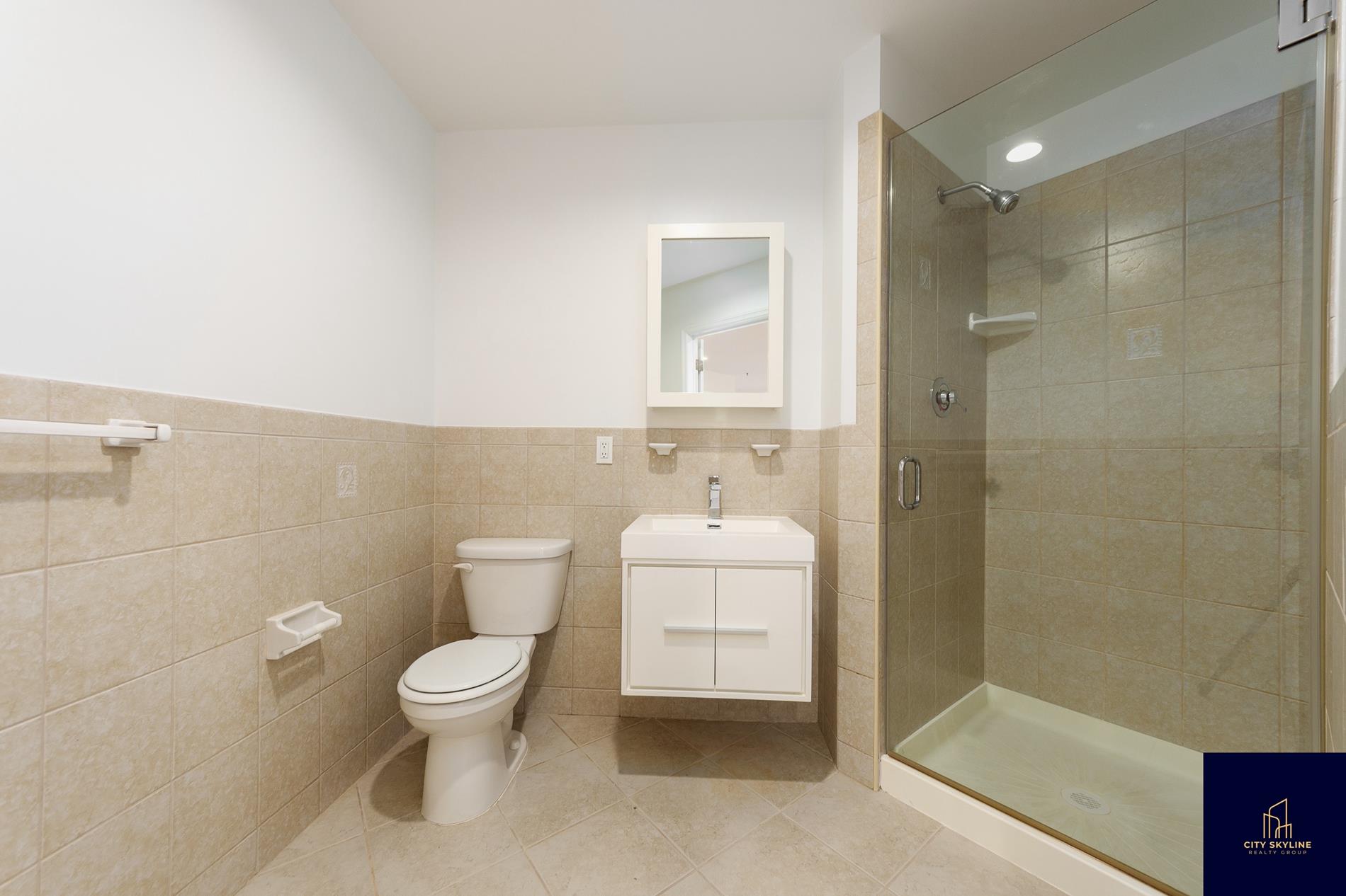 19-19 24th Avenue, Unit L706 Queens, NY 11102 - Photo 12 of 19 a bathroom with a toilet and a shower