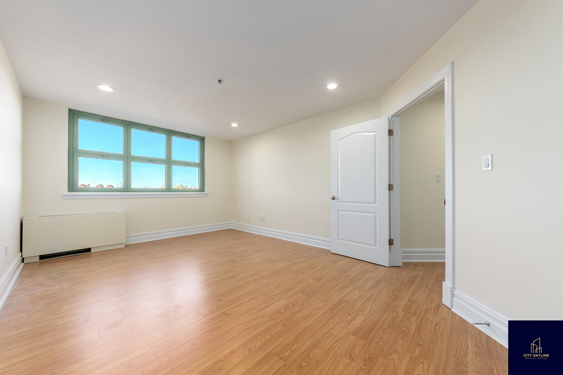 19-19 24th Avenue, Unit L706 Queens, NY 11102 - Photo 14 of 19 an empty room with wooden floor and windows