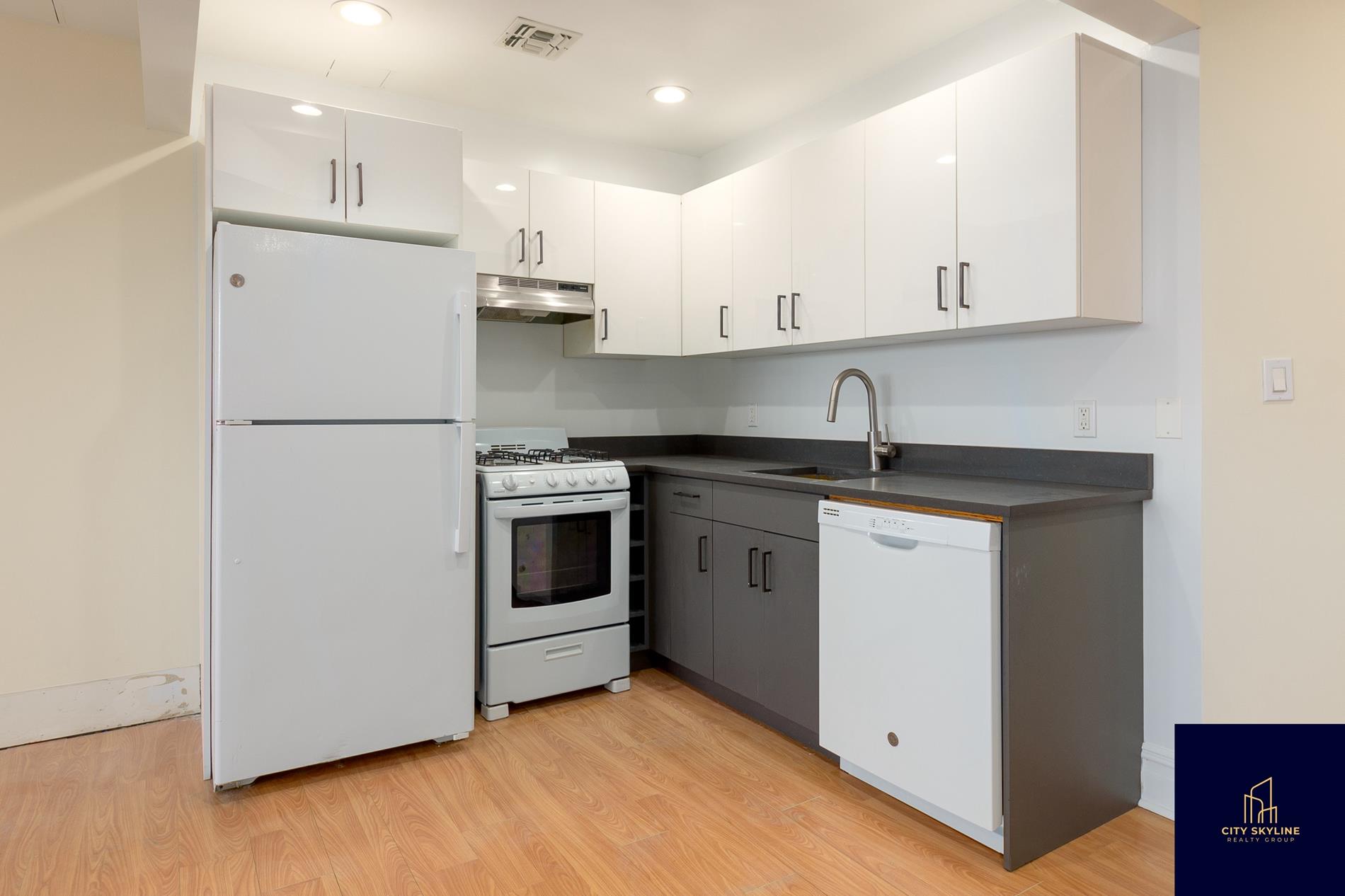 19-19 24th Avenue, Unit L706 Queens, NY 11102 - Photo 7 of 19 a kitchen with white cabinets and white appliances