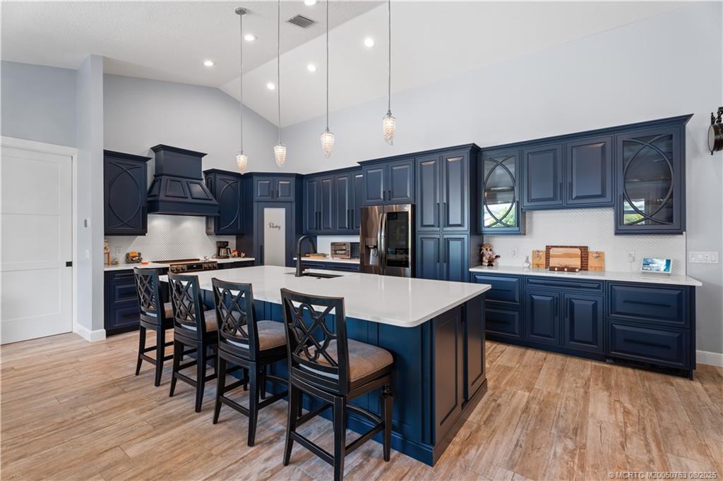 10 Copaire Road Stuart, FL 34996 - Photo 11 of 48 a kitchen with stainless steel appliances kitchen island granite countertop a table chairs sink refrigerator and cabinets