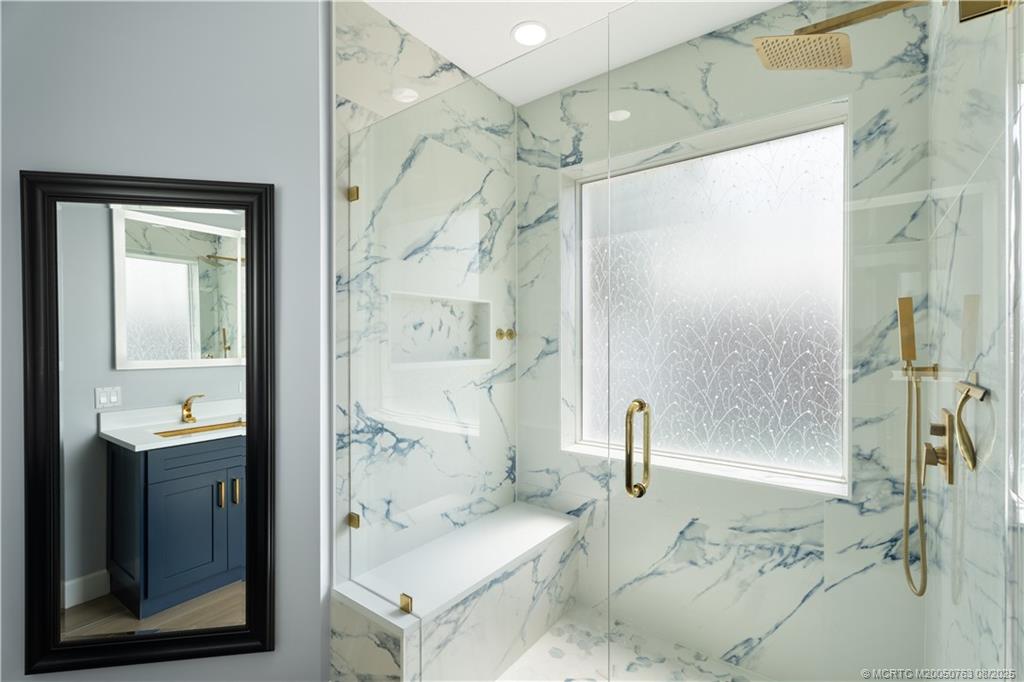 10 Copaire Road Stuart, FL 34996 - Photo 14 of 48 a bathroom with a double vanity sink a mirror and shower
