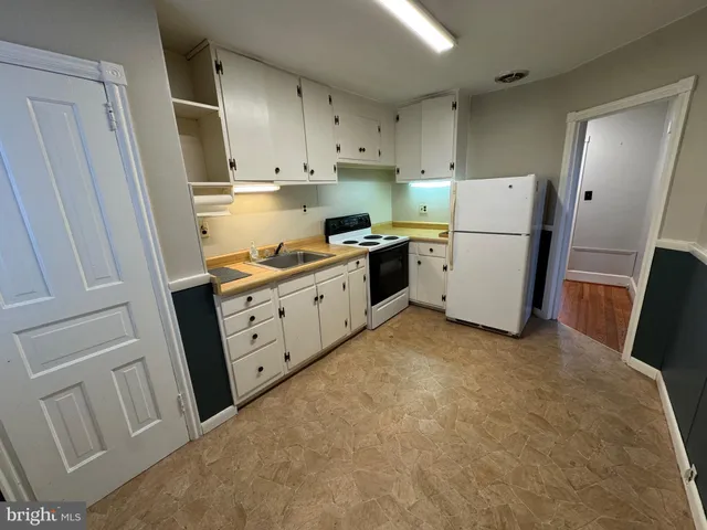 a kitchen with white cabinets and white appliances