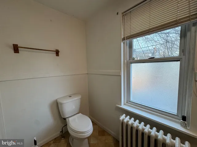 a white toilet sitting next to a window