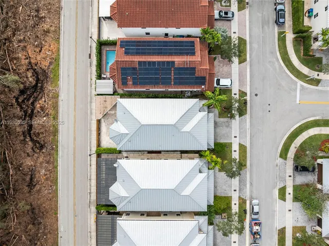 an aerial view of a house with swimming pool and large trees