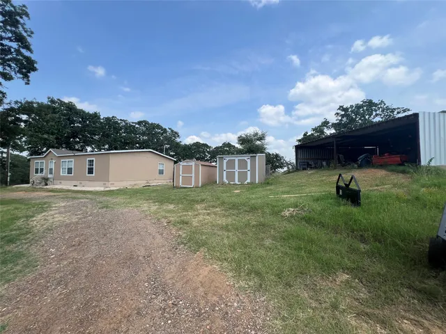 a view of a house with backyard and a garden