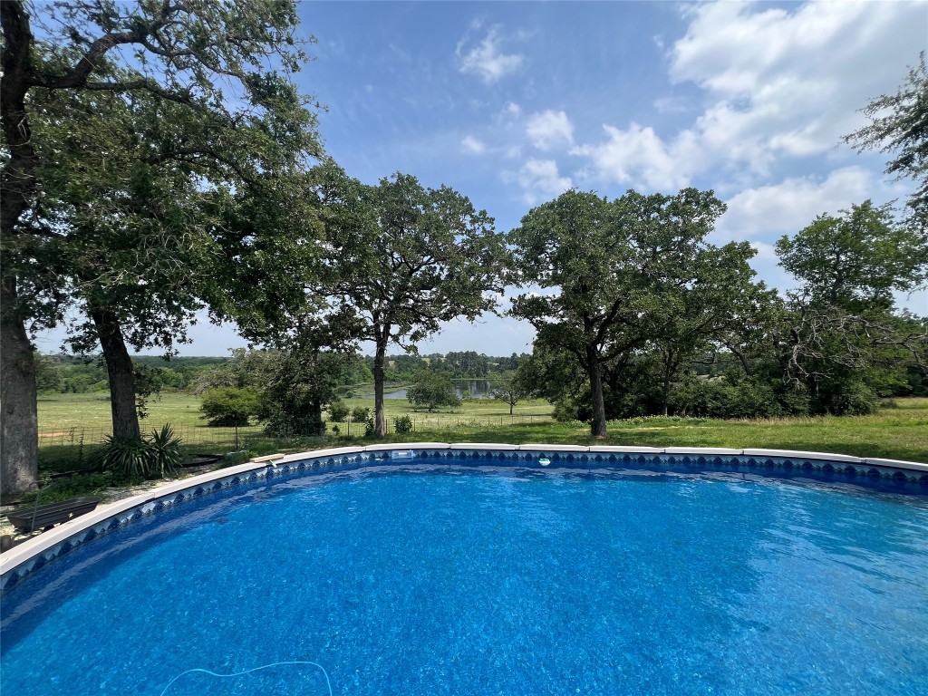 702 Paint Creek Road McDade, TX 78650 - Photo 19 of 40 a view of a swimming pool and trees in the background