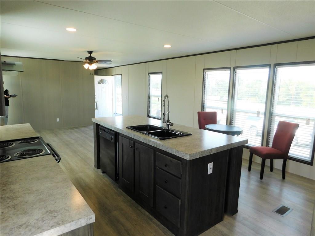 702 Paint Creek Road McDade, TX 78650 - Photo 28 of 40 a kitchen with a stove a sink a counter top space and living room area