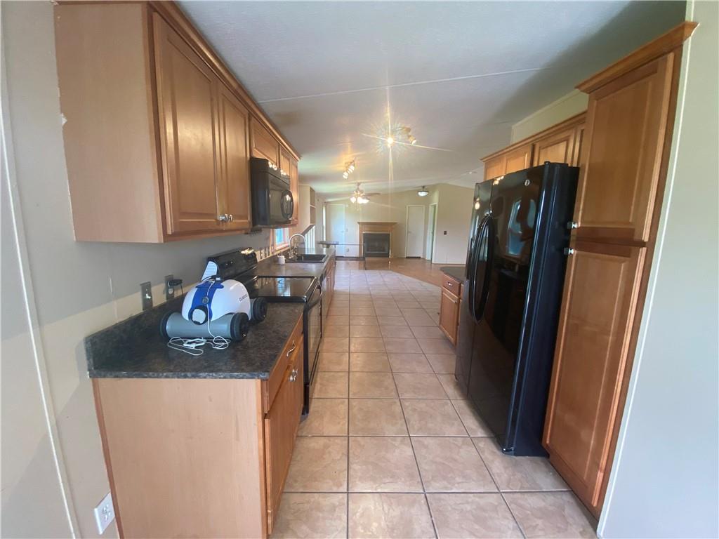 702 Paint Creek Road McDade, TX 78650 - Photo 33 of 40 a kitchen with stainless steel appliances granite countertop a refrigerator a stove and a sink