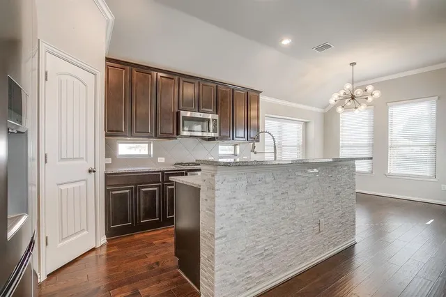 a kitchen with granite countertop a stove and a sink