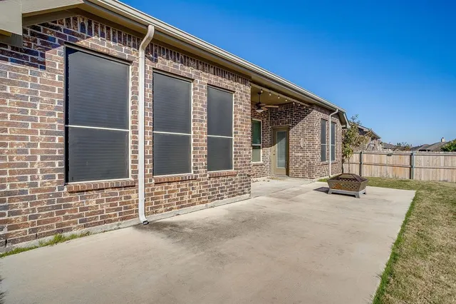 a view of backyard with brick wall and potted plants