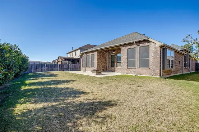 a view of a house with backyard and trees
