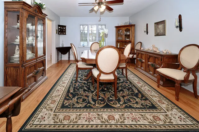 a living room with furniture two large window and a rug
