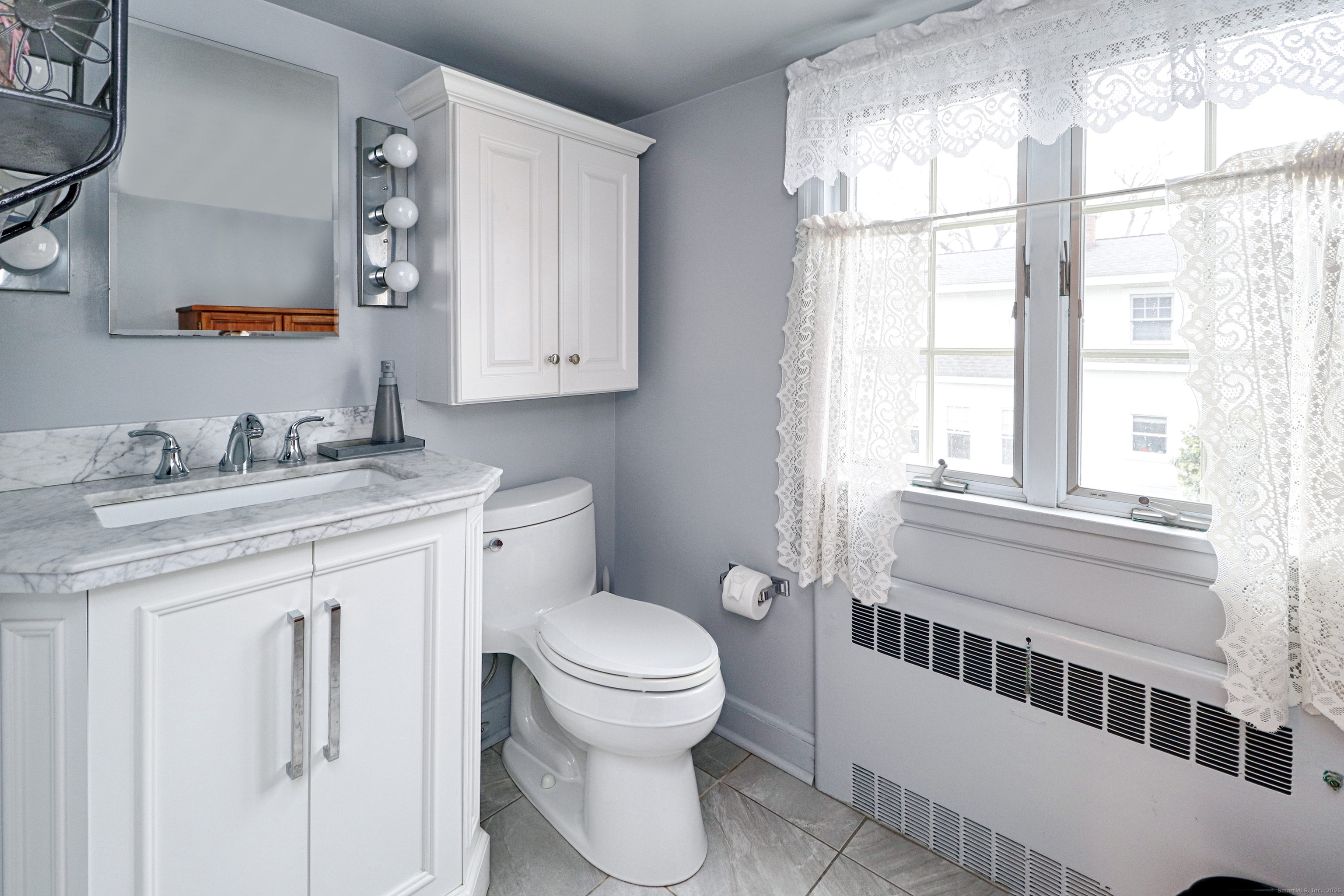 232 Church Hill Road Fairfield, CT 06825 - Photo 26 of 31 a bathroom with a granite countertop toilet a sink and a window