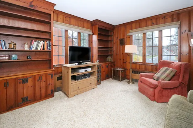 a kitchen with stainless steel appliances granite countertop a dining table chairs refrigerator and cabinets