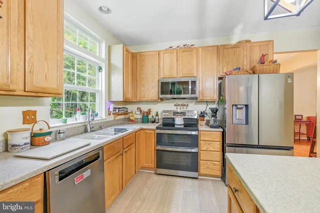 a kitchen with stainless steel appliances a refrigerator sink and cabinets