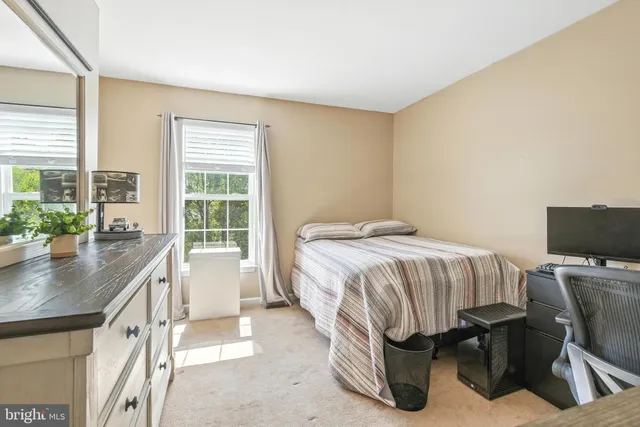 a bed sitting in a bedroom next to a window