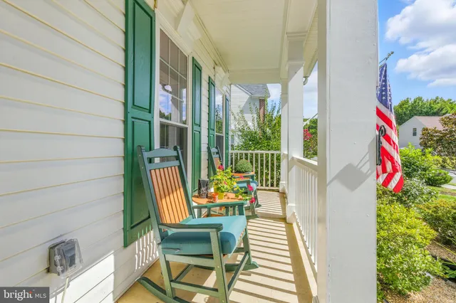 a balcony with chairs and with potted plants