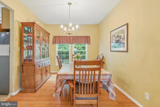 a view of a dining room with furniture a chandelier and wooden floor